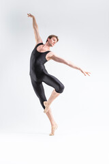 Obraz premium Modern Ballet Dancing. Contemporary Art Ballet of Young Caucasian Athletic Man in Black Suit Dancing in Studio