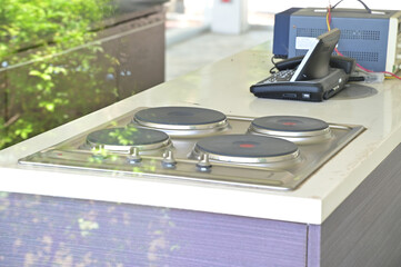 Closeup of Four induction cookers or Kitchen electric stove and a telephone in the kitchen inside...