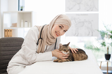 Positive female veterinary posing on camera with fluffy cat