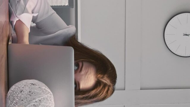 Vertical video. Office leisure. Job irresponsibility. Lazy woman secretary pretending work using mobile phone when boss out sitting at workplace.