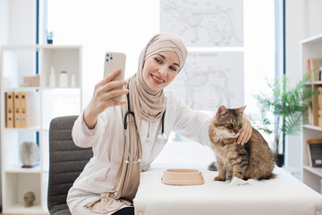 Muslim lady taking selfie of animal patient at vet visit