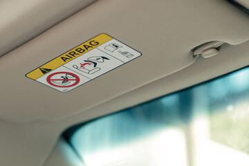 airbag warning label on sun visor, signs of airbag system