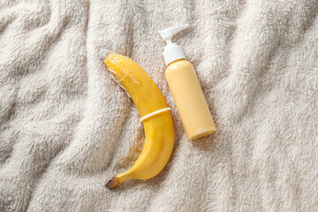 Condom on a banana with lubricant on a light background