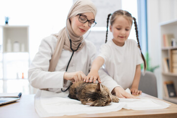 Doctor listening to pet's lungs with stethoscope near child