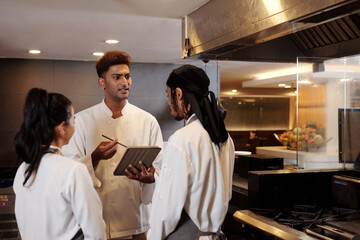 Restaurant chef talking to his team in the beginning of shift