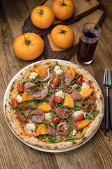 Delicious pizza with meat and yellow tomatoes 