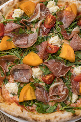 Delicious pizza with meat and yellow tomatoes 