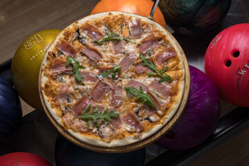 Delicious pizza with meat in a bowling club