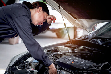 Fototapeta na wymiar Beautiful female auto mechanic in uniform working with engine vehicle at garage, car service technician woman checking and repairing customer car at automobile service center, vehicle repair service.