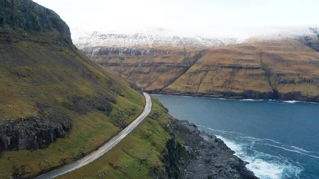 Faroe Islands 4K Aerial of Tj&oslash;rnuv&iacute;k, Streymoy. Sunset tracking push in and orbit around mountain following the road to reveal Tj&oslash;rnuv&iacute;k