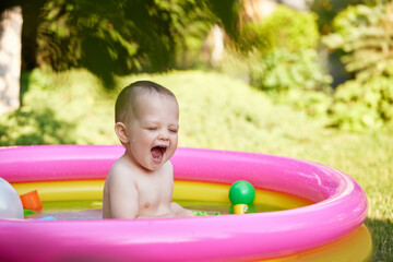 cute baby girl swimming in kid inflatable pool
