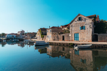 Obraz premium Vrboska village embankment, houses are reflected in the water. Hvar island, Croatia