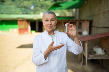 Woman veterinarian with a test tube of tests at a rabbit farm.