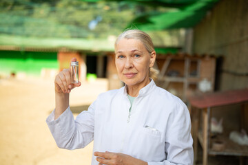 Woman veterinarian with a test tube of tests at a rabbit farm.