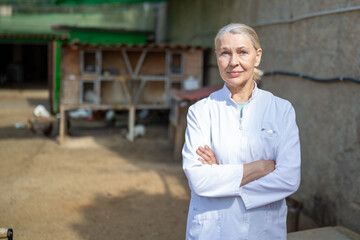 A female veterinarian stands at a rabbit farm after an examination.