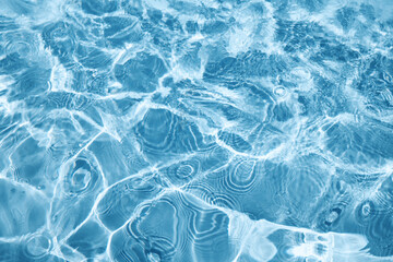 Naklejka premium Abstract water background with ripples. Light caustics effect. Play of light and shadow, texture of twaves and splashes.
