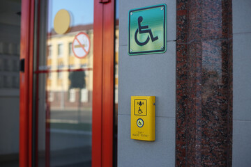 Yellow panel with a call button for help for people with disabilities on a wheelchair to enter the...
