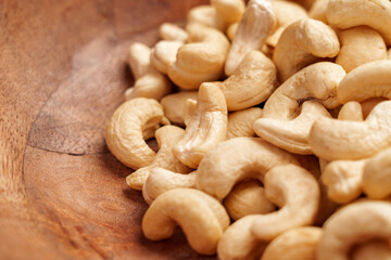 Fresh natural raw cashew nuts in wooden bowl