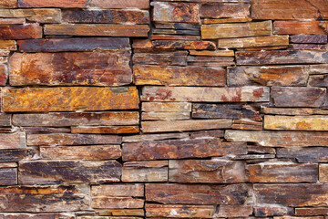 A wall made of brown stone blocks of the facade. Abstract natural background
