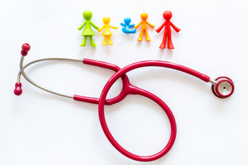 Family medicine concept. Stethoscope and family rubber figurines, top view