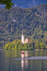 Fototapeta premium Church of the Assumption of Mary in the center of the lake Bled. Small island on Bled Lake in Slovenia, vertical view.
