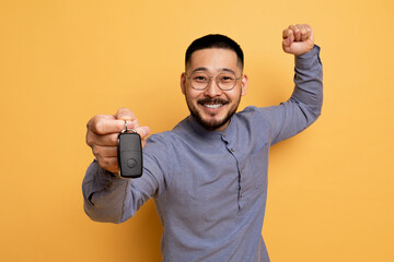 New Vehicle. Excited Young Asian Man Holding Car Key In His Hand