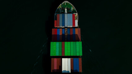 Fototapeta na wymiar top view head shot of cargo container ship sailing in dark sea background to import export goods and distributing products to dealer and consumers worldwide, by container ship