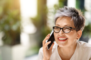 Closeup of wealthy mature lady have phone conversation, copy space
