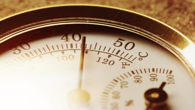 Close-up round vintage thermometer on desert sand, high temperature, air temperature rises under sunlight. Thermometer needle moves to 50 degrees of heat. Hot weather, global warming concept