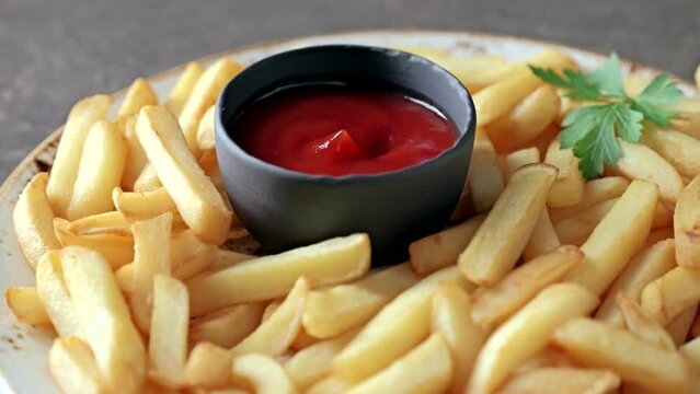 French fries, tomato ketchup. Close-up of dipping french fries.