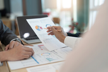 Asian business team is meeting for a project to establish and plan. Discussion of graphs and chart data analysis business finance graph and accounting concept