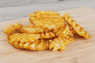 Delicious Waffle Fries isolated on a wooden background