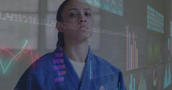 Animation of graphs and number charts, serious biracial martial female artist standing against wall