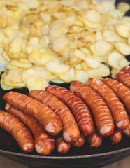 Food festival with food stall kiosk, open-air outdoor fair market, assortment of different traditional European grilled barbecued street food with sausages, bbq, chicken, pork and lamb on a large pan