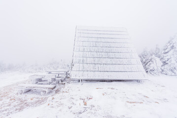 A frozen shelter in fog at the Cerne Sedlo in Krkonose national park in cold winter day.