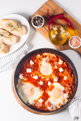 Shakshuka made of poached eggs in tomato pepper sauce