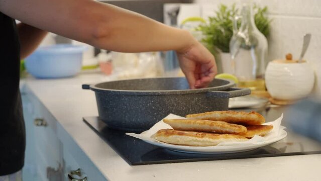 woman cooking homemade pasties frying chebureks in the kitchen at home