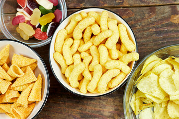 birthday or christmas, new year's party concept, a bowls of different chips and candies on  wooden table