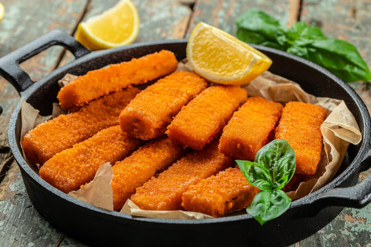 crumbed fish fingers sticks served with lemon. Food recipe background. Close up