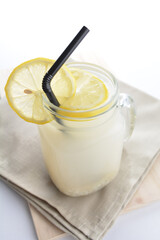 cold iced healthy lemon barley juice with lemon slice in cocktail glass black straw on grey cloth white background asian beverage halal food drink menu for hotel bar cafe