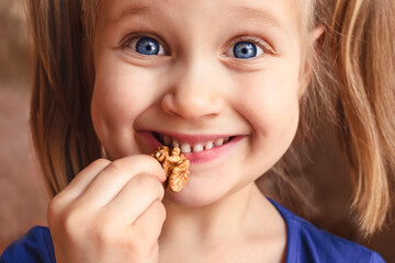 Walnut for Children. Walnuts in Child Hands Close up. Happy Smiling Kid Girl Eating Nuts Closeup....