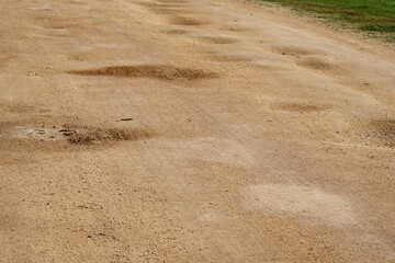 dirt road with pot holes in selective focus