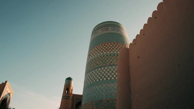 Ancient architecture of city of Khiva. Uzbekistan. Kalta Minor Minaret at Sunset. Medieval oriental architecture, central Asia. Silk road. Popular travel destination. Old islamic town