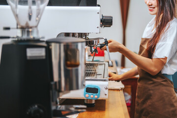 .Barista hands coffee barista woman make hot cup espresso shot from coffee machine.