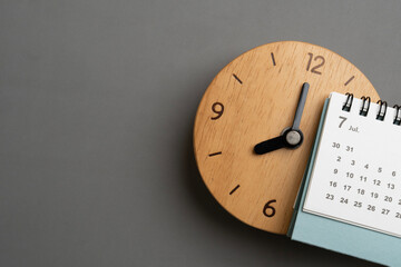 close up of calendar and clock on the gray table background, planning for business meeting or travel planning concept