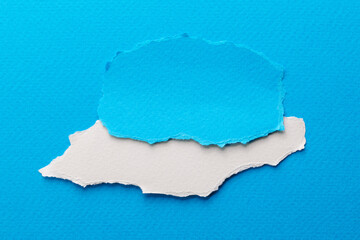 Art collage of pieces of ripped paper with torn edges. Sticky notes collection blue white colors, shreds of notebook pages. Abstract background.
