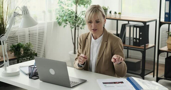 Businesswoman participating in a video call while referring to important documents. With a focused demeanor, she seamlessly integrates the information from the documents into the discussion.