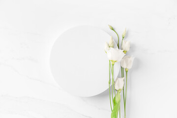 Delicate beauty cosmetics product presentation scene made with white circle podium and eustoma flowers on white table.