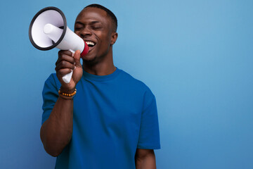 young successful handsome american guy dressed in a basic t-shirt speaks news into a megaphone