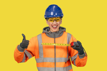 Woman in blue hard hat and yellow protective clothes land surveyor working with modern surveying...